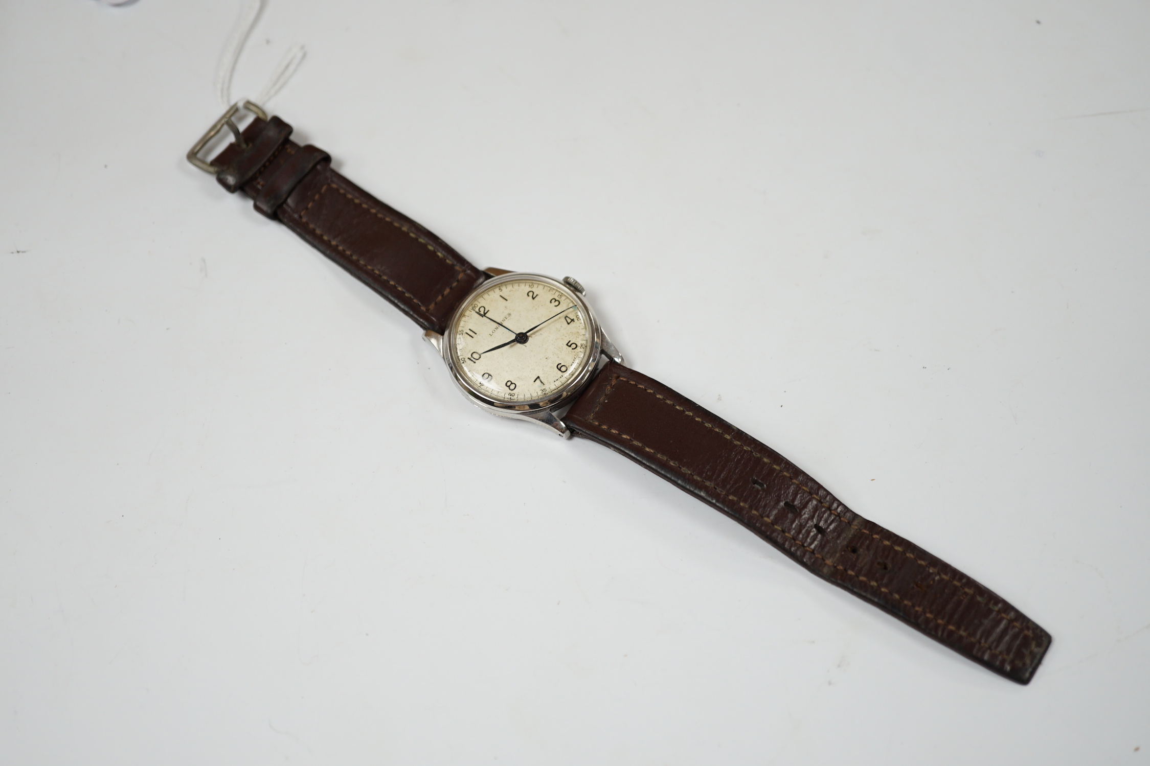 A gentleman's mid 20th century stainless steel Longines manual wind wrist watch, on associated leather strap, case diameter 34mm.